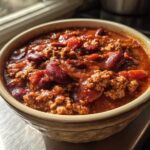 Close-up of a bowl filled with rich, thick high protein chili featuring ground meat and kidney beans.