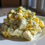A generous mound of creamy egg salad recipe, featuring chopped eggs, mayonnaise dressing, and fresh dill, served on a white plate.