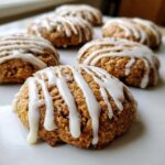 Close-up of soft, gooey persimmon cookies drizzled generously with white vanilla icing.