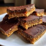 A stack of rich graham cracker toffee bars featuring a crumbly base, gooey caramel layer, and smooth chocolate topping.