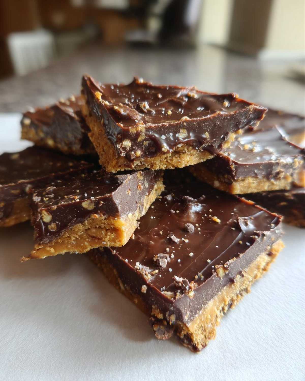 A stack of rich graham cracker toffee squares topped with melted chocolate and sea salt flakes.