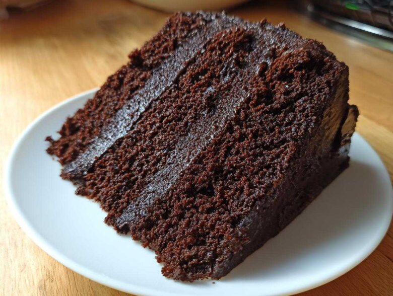Close-up of a rich, dark slice of chocolate cake recipe with moist crumb and frosting.