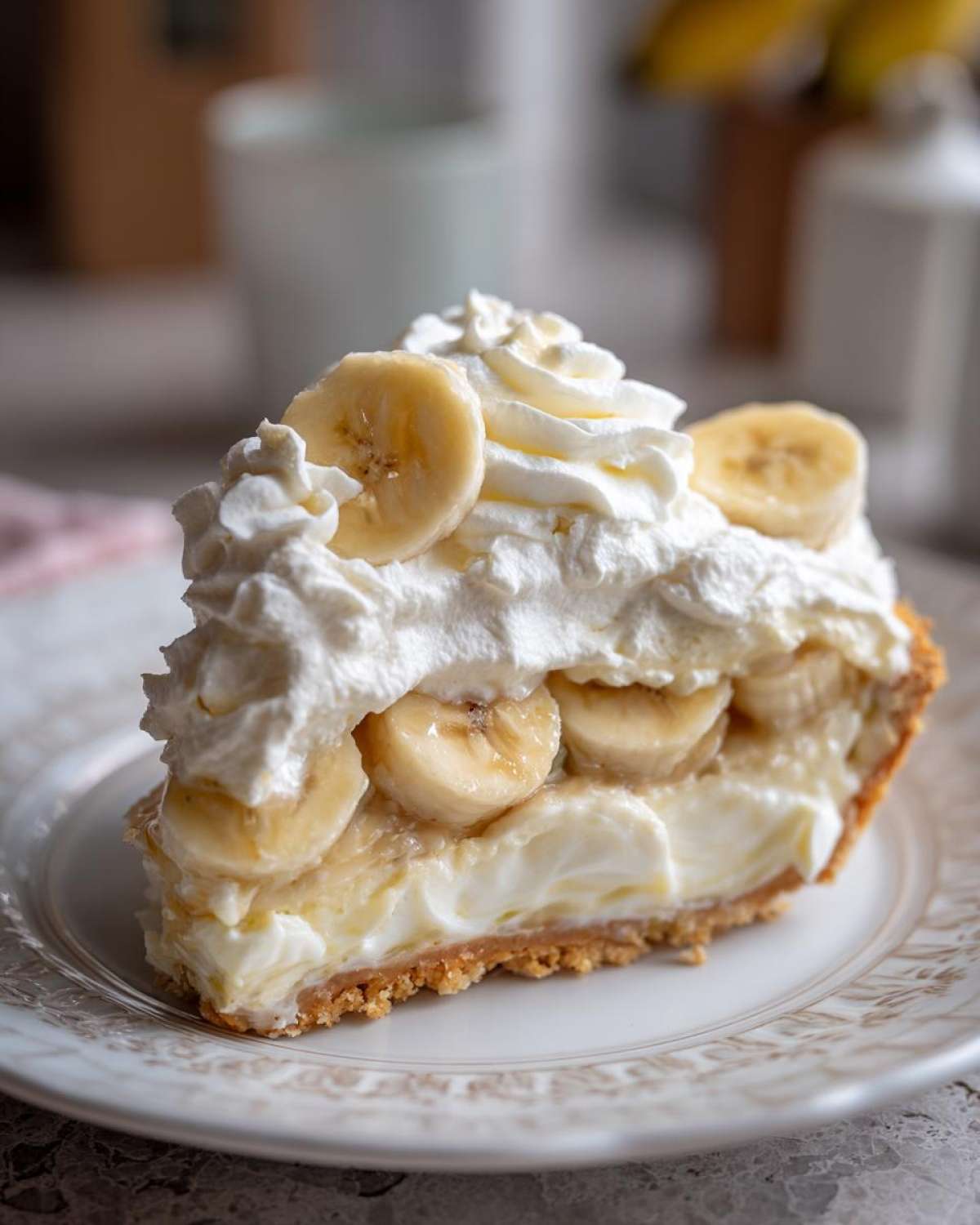 A decadent slice of banana cream pie recipe featuring thick custard, fresh banana slices, and whipped cream topping.
