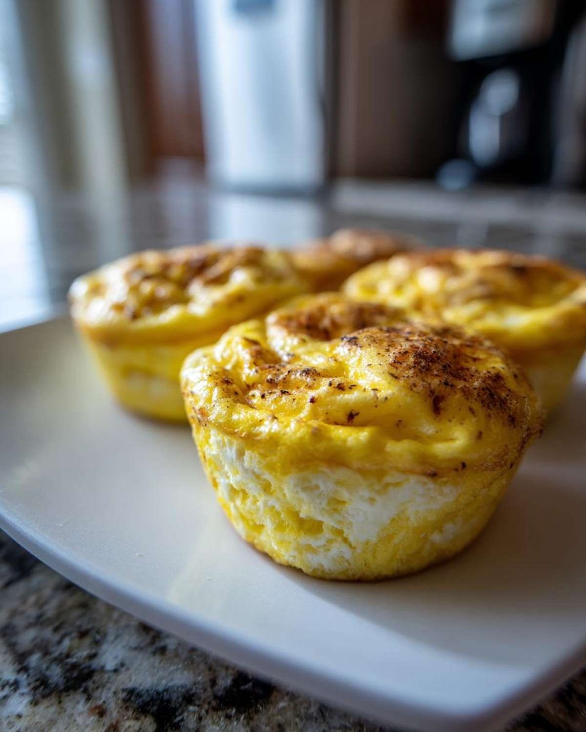 Close-up of three fluffy cottage cheese egg cups starbucks style on a white plate.