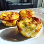 Three golden-brown cottage cheese egg cups starbucks style served on a white plate.