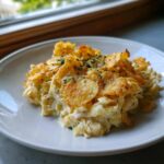 A serving of creamy Tuna Casserole topped with golden, crispy potato chips and sprinkled with parsley.