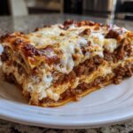 A thick, well-layered slice of homemade lasagna featuring rich meat sauce and melted mozzarella cheese.