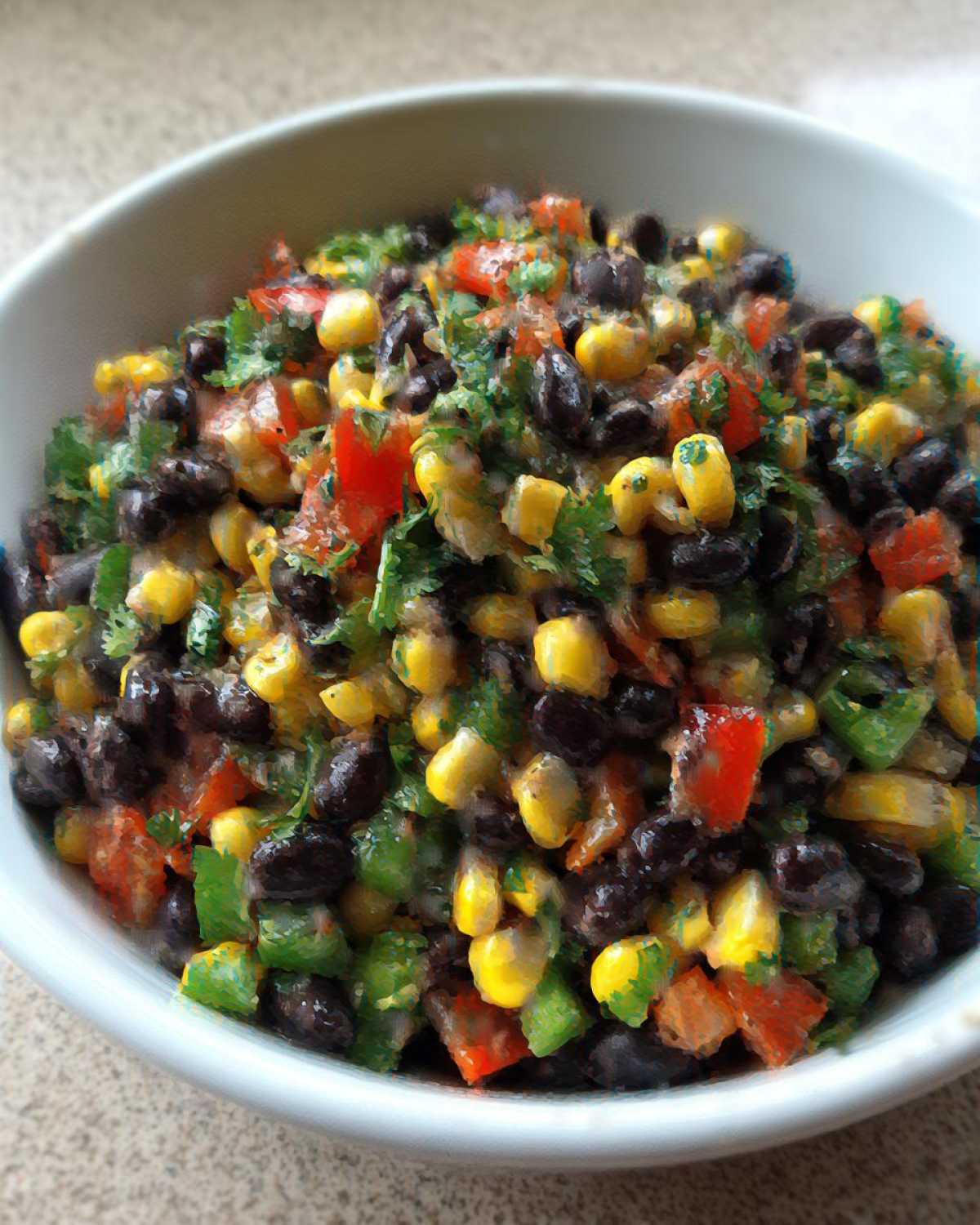 Close-up of vibrant cowboy caviar dip featuring black beans, corn, diced red and green peppers, and cilantro.