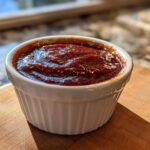 Close-up of thick, rich homemade bbq sauce served in a small white fluted ramekin.