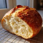 Close-up of the airy, open crumb structure inside a freshly baked Italian bread loaf.