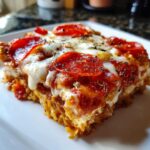 A close-up of a square serving of 1 pot pizza pasta topped with melted mozzarella, tomato sauce, and pepperoni slices.