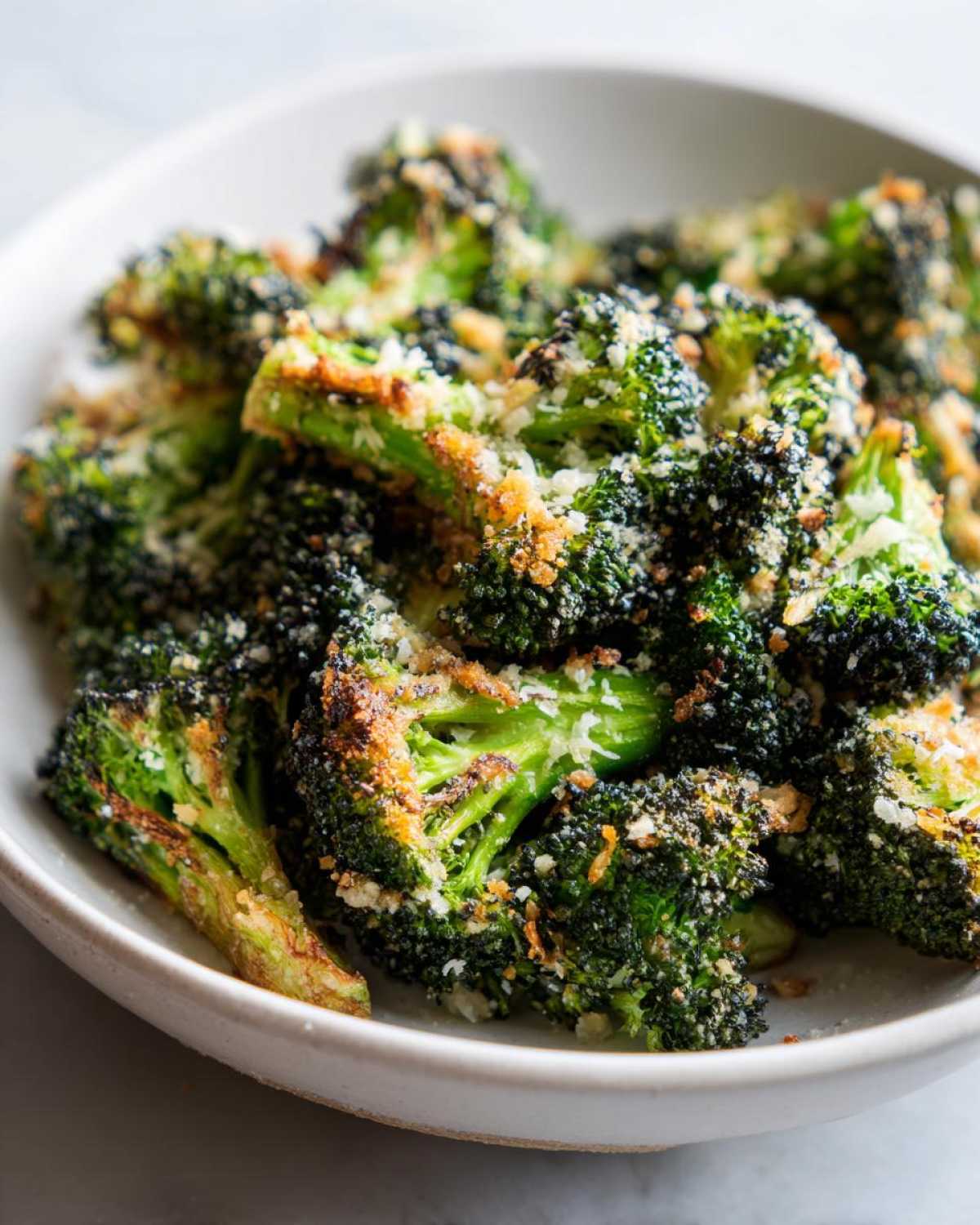 Close-up of perfectly roasted broccoli florets topped with crispy breadcrumbs and Parmesan cheese.