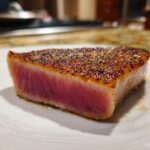 Close-up of a perfectly seared tuna steak showing a rare pink center and a seasoned crust, ready after using the MARINADE FOR TUNA STEAK.