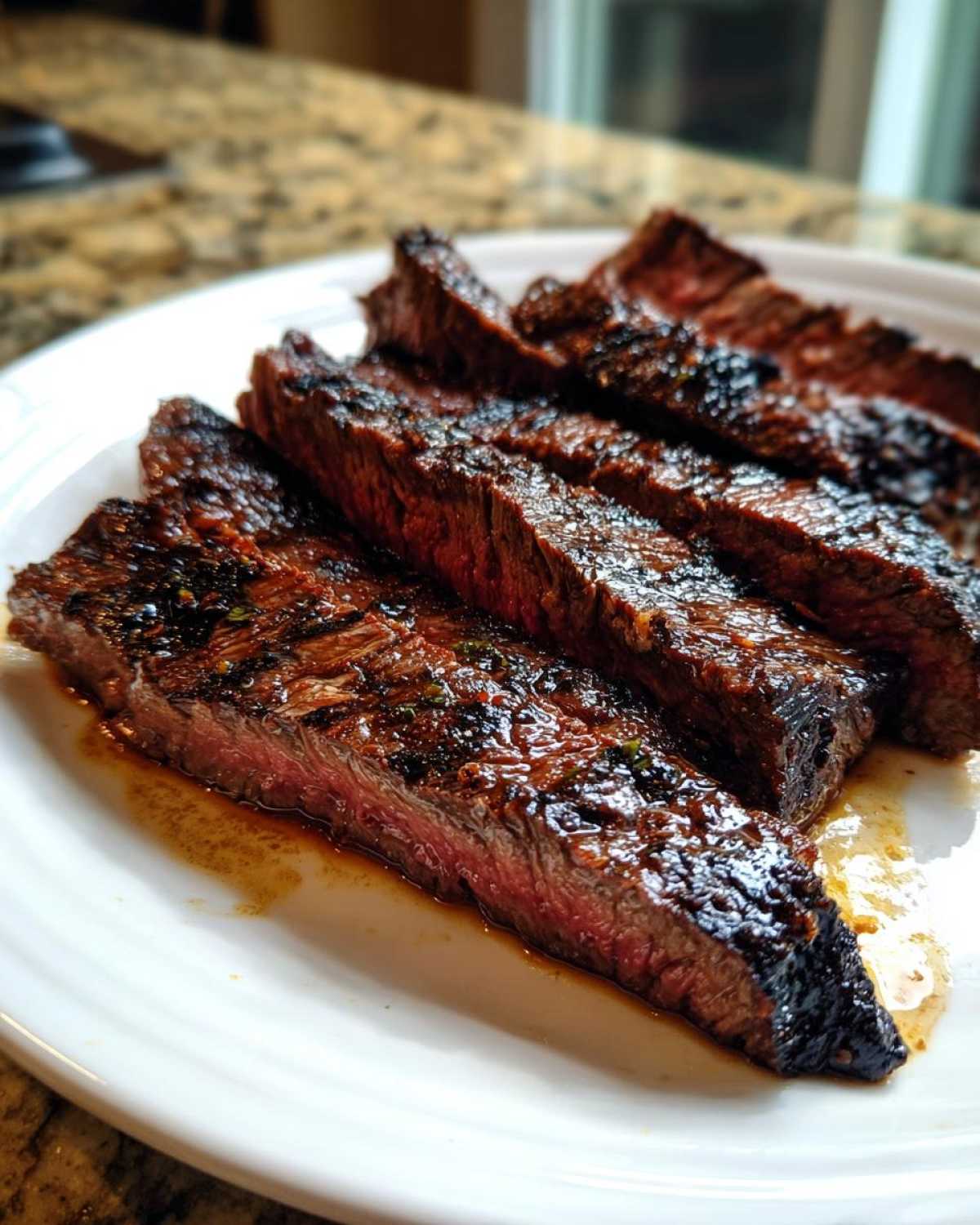 Close-up of medium-rare steak slices showing char marks, glistening with juices from the carne asada marinade.