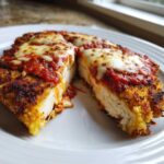 A cross-section view showing the juicy interior of Air Fryer Chicken Parmesan topped with melted mozzarella and marinara sauce.