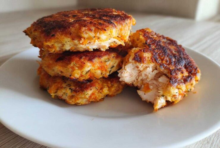 Stack of golden brown Air Fryer Salmon Patties, one broken open showing flaky interior.