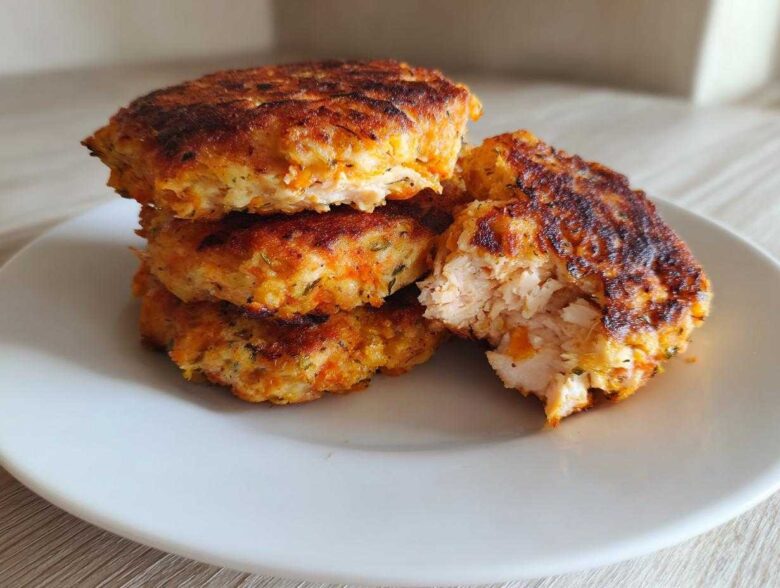 Stack of golden brown Air Fryer Salmon Patties, one broken open showing flaky interior.