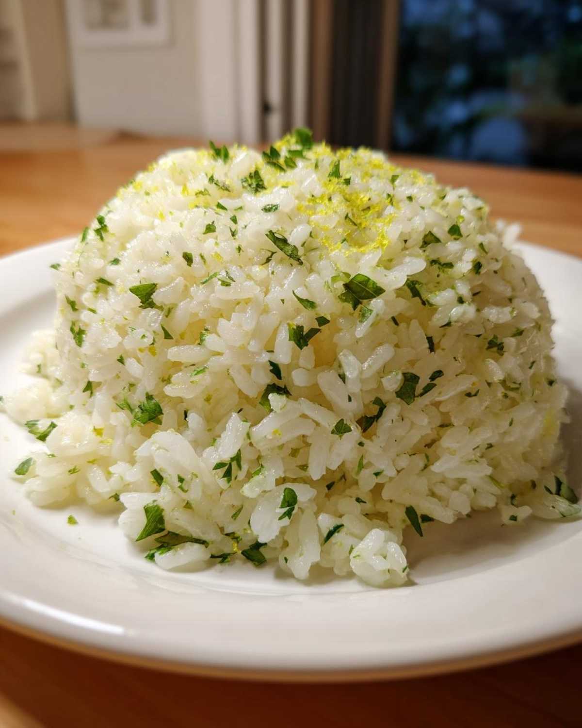 A perfectly molded serving of fluffy Cilantro Lime Rice, topped with fresh cilantro and lime zest.