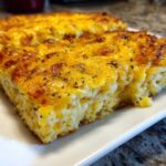 Two slices of golden brown Copycat Cracker Barrel Hashbrown Casserole on a white plate.