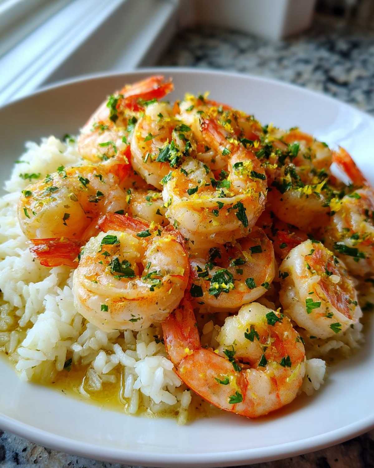 Close-up of Garlic Butter Shrimp and Rice Skillet, featuring plump shrimp over white rice with a buttery sauce and parsley garnish.