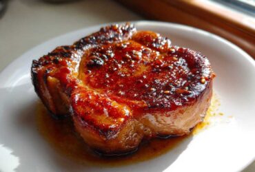 Close-up of a perfectly seared Honey Glazed Ham Steak in the Skillet with a shiny, caramelized glaze.