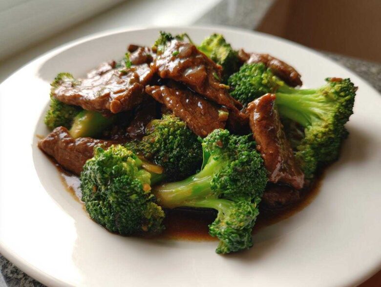 A close-up serving of glossy Instant Pot Beef and Broccoli featuring tender beef strips and bright green florets coated in savory sauce.