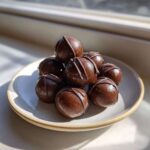 A stack of rich, chocolate-covered Keto Chocolate Peanut Butter Fat Bombs drizzled with extra chocolate.