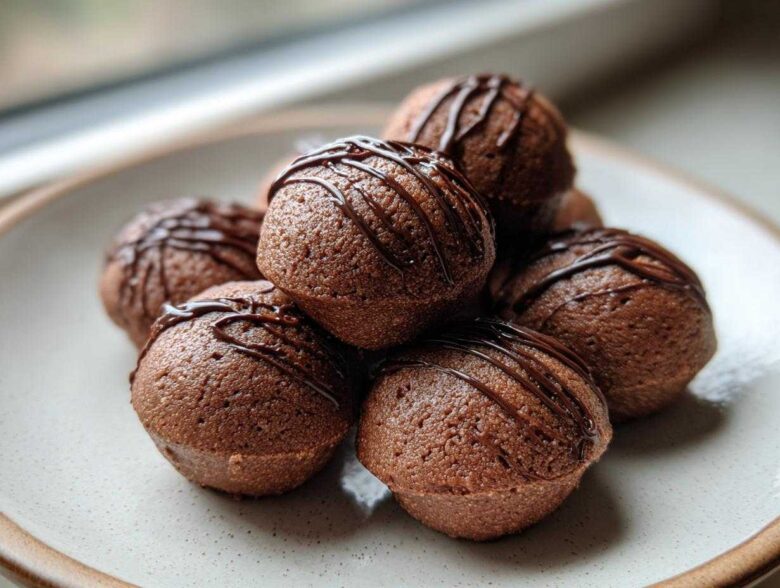 A stack of rich, dark brown Keto Chocolate Peanut Butter Fat Bombs drizzled with melted chocolate.