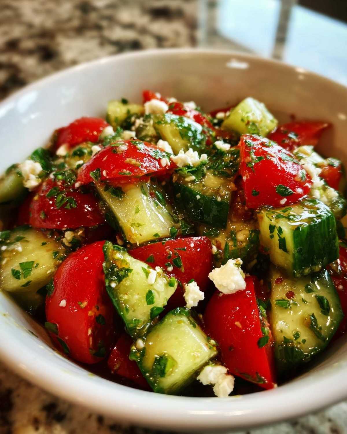 Close-up of vibrant Mediterranean Cucumber Tomato Salad with chunks of cucumber, red tomatoes, feta cheese, and herbs.