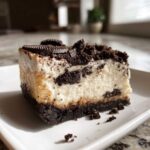 A rich, creamy slice of No-Bake Oreo Cheesecake with a dark chocolate crust and cookie topping.