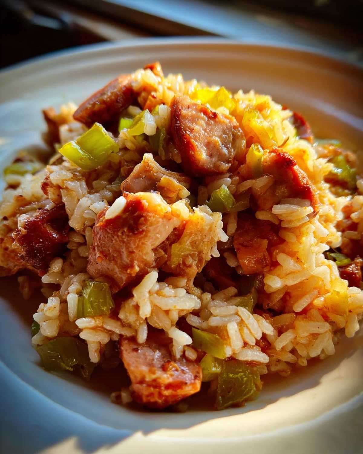 A close-up serving of One-Pot Chicken Jambalaya featuring rice, chunks of sausage, and green bell peppers.