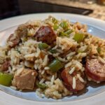 Close-up of a serving of One-Pot Chicken Jambalaya featuring rice, chicken chunks, and sliced smoked sausage.
