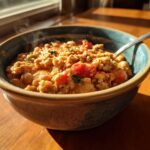 A steaming bowl of Spicy Turkey White Bean Chili featuring ground turkey, white beans, and tomatoes, set near a sunny window.