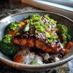 Close-up of a Teriyaki Salmon Rice Bowls serving with glazed salmon, rice, broccoli, and carrots.