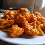 Close-up of bright orange marinated cauliflower florets ready for Vegan Cauliflower Tikka Masala.