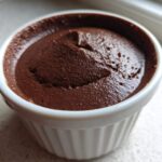 Close-up of rich, dark Vegan Chocolate Avocado Mousse served in a white, fluted ramekin.