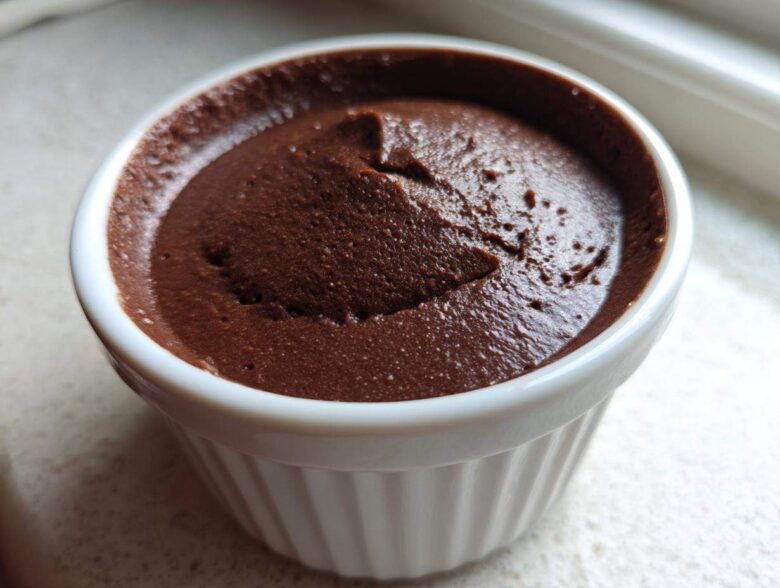 Close-up of rich, dark Vegan Chocolate Avocado Mousse served in a white, fluted ramekin.