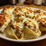 Close-up of baked Cheesy Ground Beef Stuffed Shells with Cream Sauce, featuring golden-brown melted cheese.