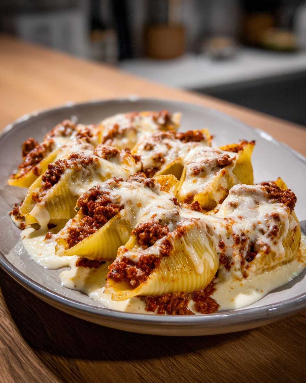 Close-up of baked Cheesy Ground Beef Stuffed Shells with Cream Sauce, topped with melted mozzarella.