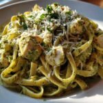 A close-up of rich Creamy Pesto Chicken Pasta with Mozzarella, topped with grated cheese and parsley.