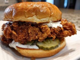 A close-up of a Crispy Chicken Sandwich with Garlic Sauce, featuring a thick fried chicken patty, pickles, and a brioche bun.