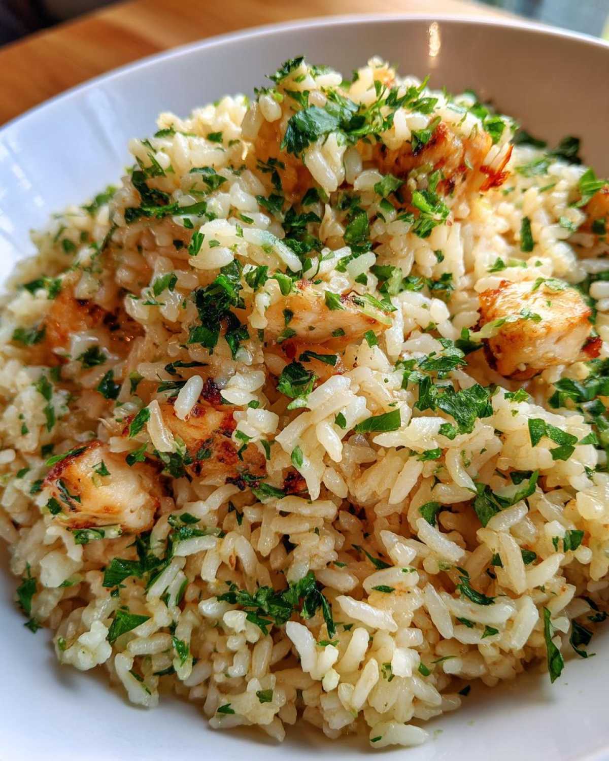 Close-up of Garlic Butter Rice with Chicken Skillet, featuring seasoned rice, seared chicken pieces, and fresh parsley.