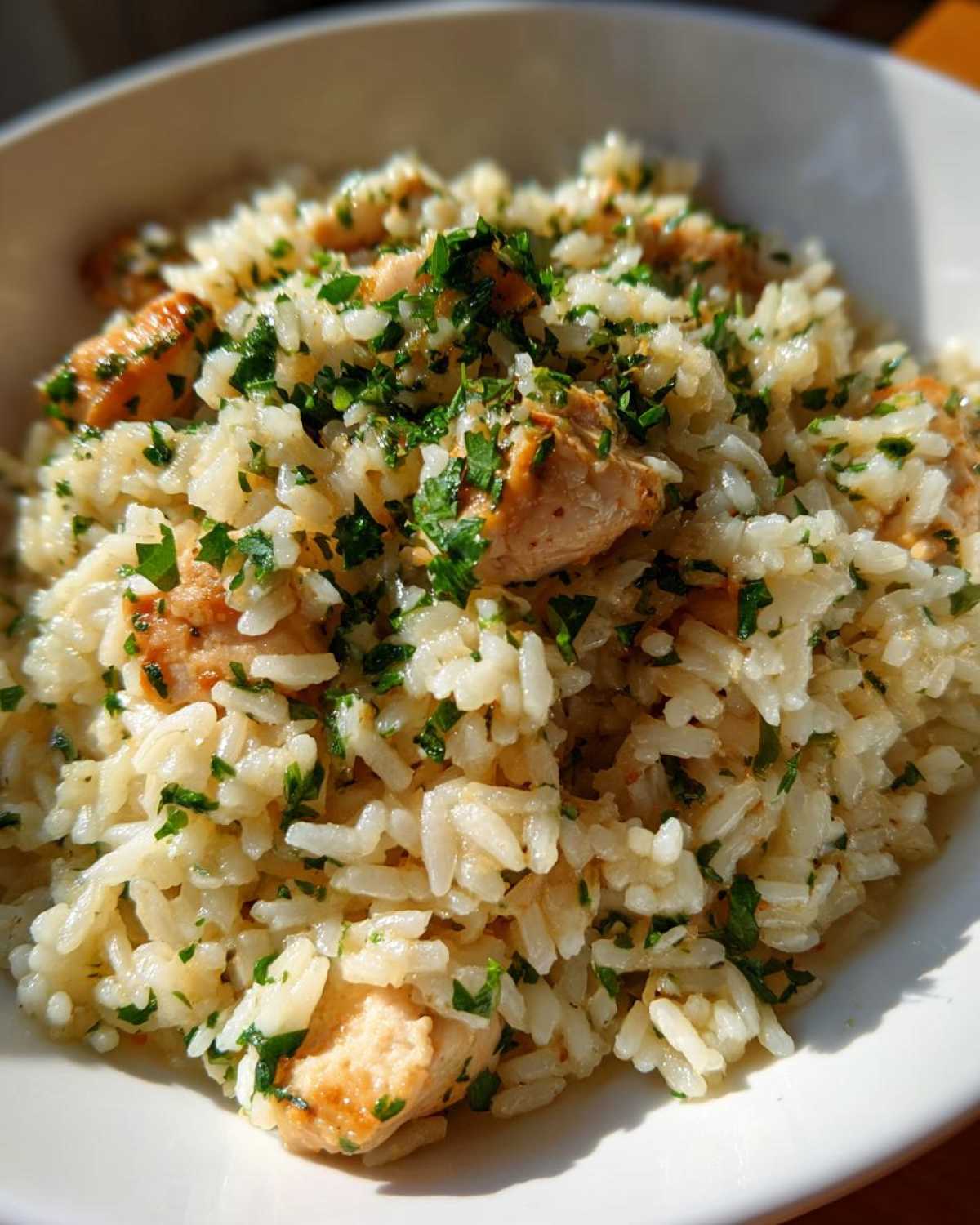 Close-up of Garlic Butter Rice with Chicken Skillet, topped generously with fresh chopped parsley.