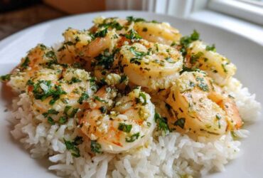 Plated serving of Garlic Butter Shrimp and Rice Easy Recipe, topped with fresh parsley.