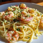 Close-up of creamy Garlic Butter Shrimp Pasta topped with parsley and visible garlic bits.
