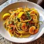 A close-up of Garlic Butter Shrimp Pasta with Lemon Flavor, topped with parsley and lemon zest.