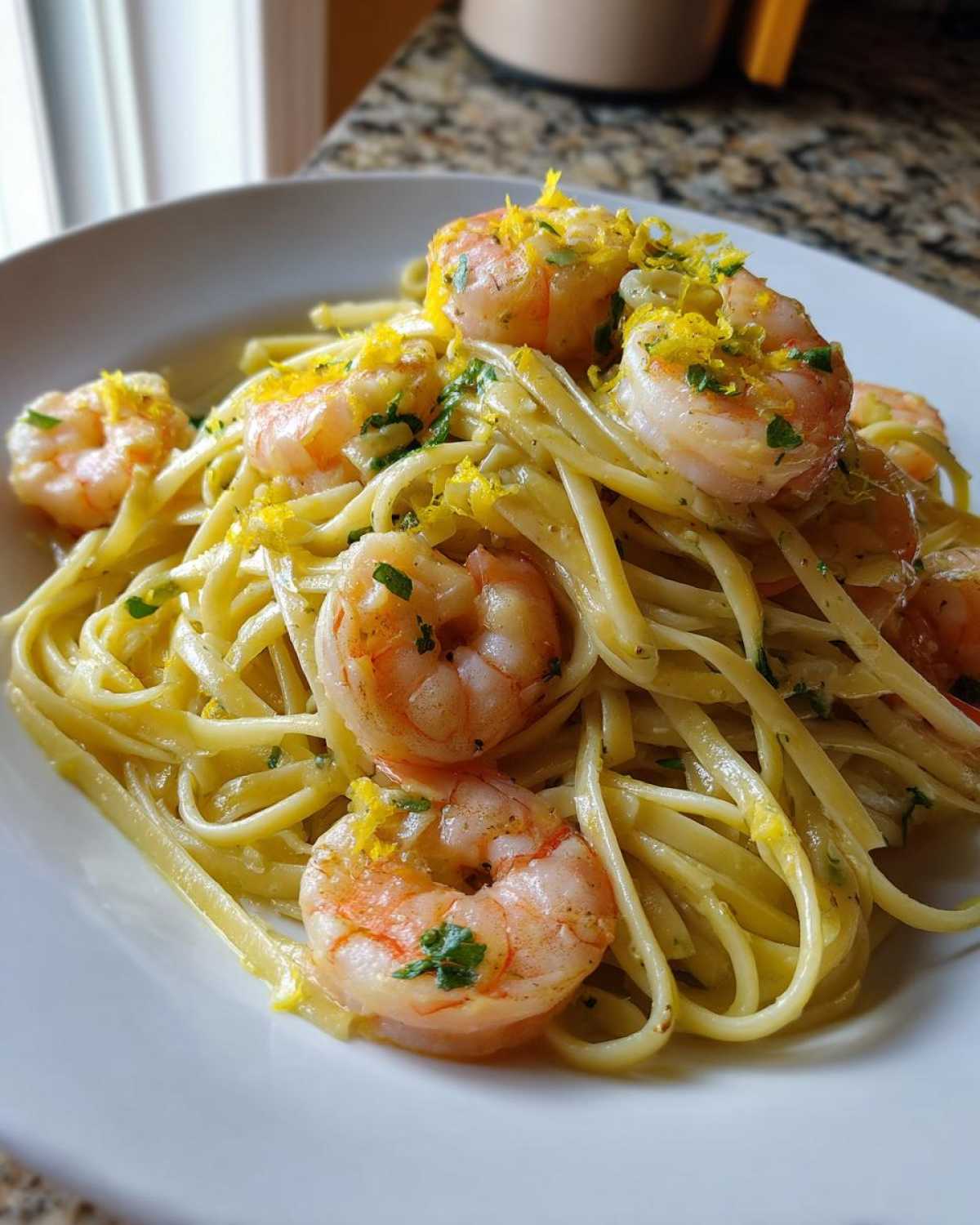 Close-up of Garlic Butter Shrimp Pasta with lemon flavor, topped with bright lemon zest and parsley.