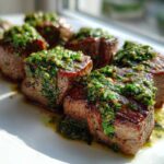 Close-up of seared Garlic Butter Steak Bites generously topped with a vibrant green herb sauce.