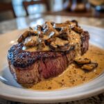 A perfectly cooked steak topped with rich, creamy mushroom sauce, showcasing the Garlic Butter Steak with Creamy Mushroom Sauce.