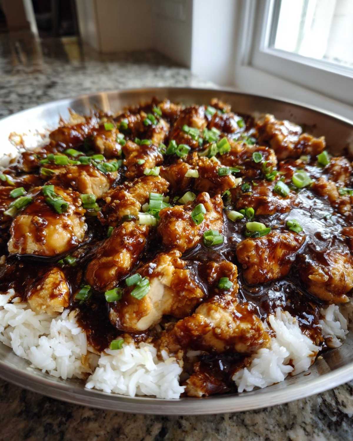 Close-up of Honey Garlic Chicken Skillet with Rice, featuring glazed chicken pieces over white rice, topped with green onions.